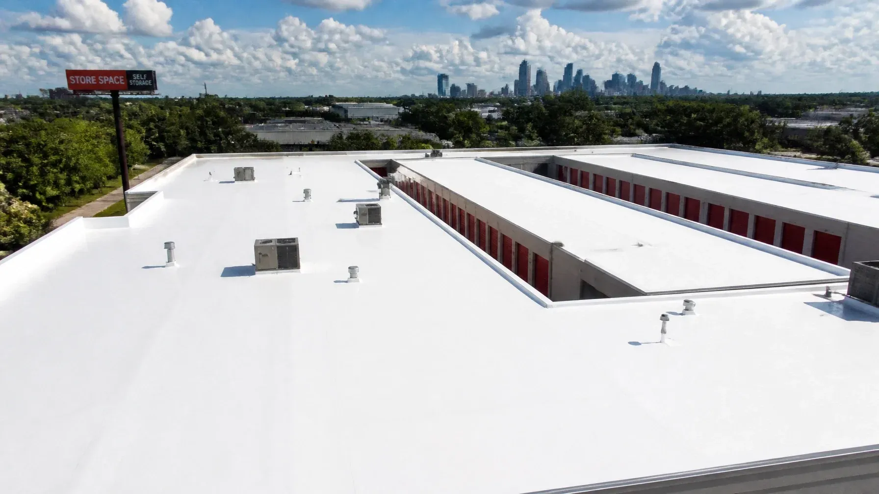 Aerial view of a bright white commercial warehouse roof in Houston